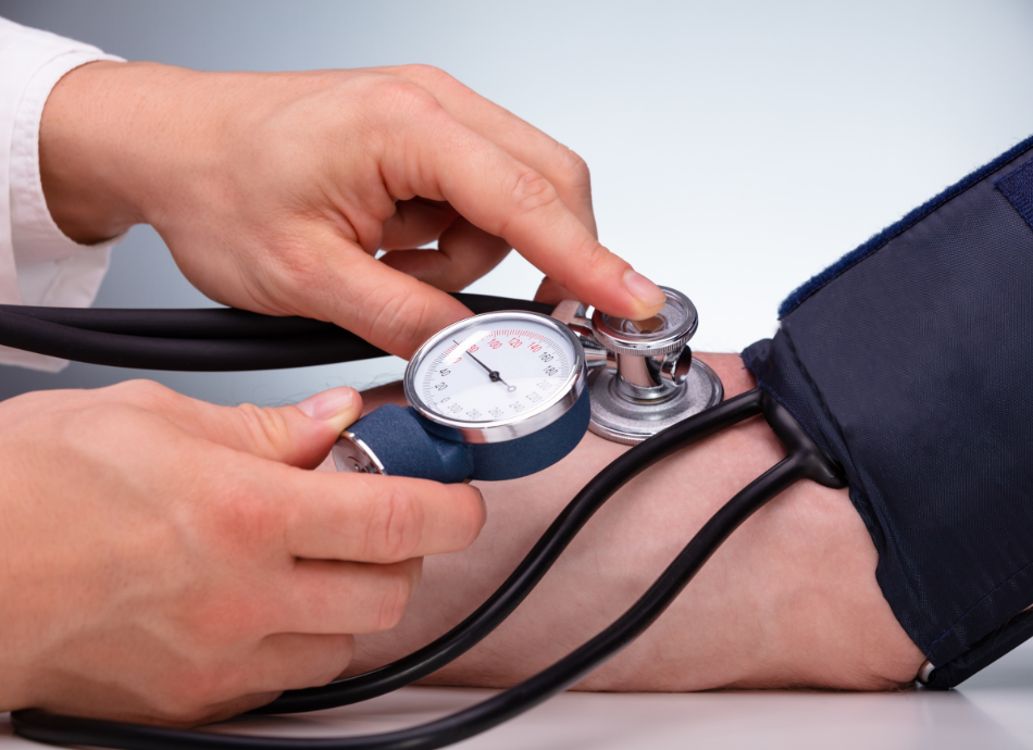 Closeup of man's arm with blood pressure cuff and monitor