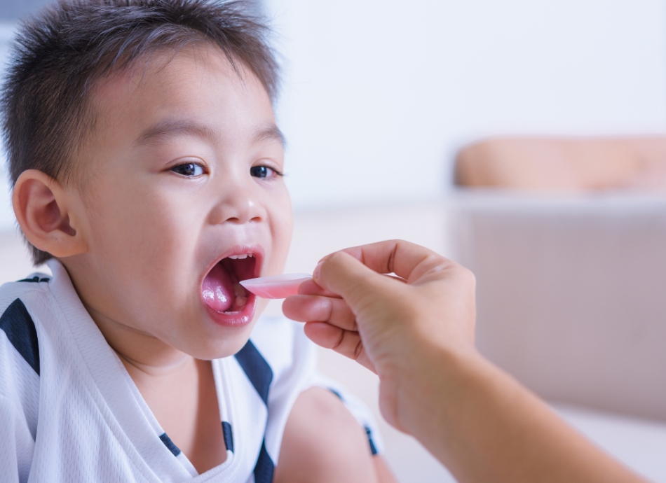 Child having medicine from spoon 