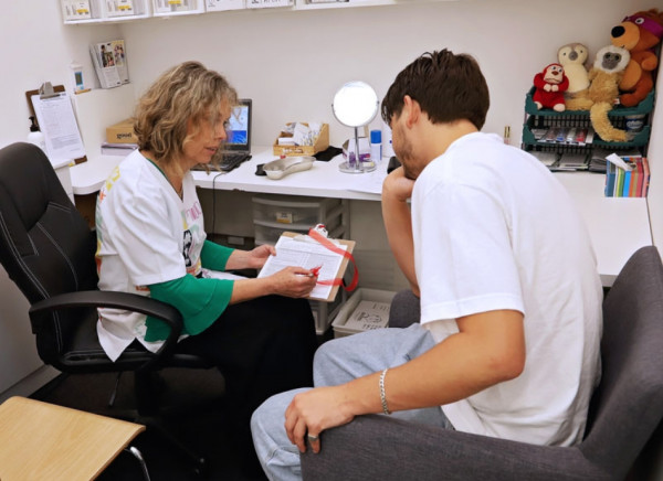 Pharmacist going over vaccination consent form with person