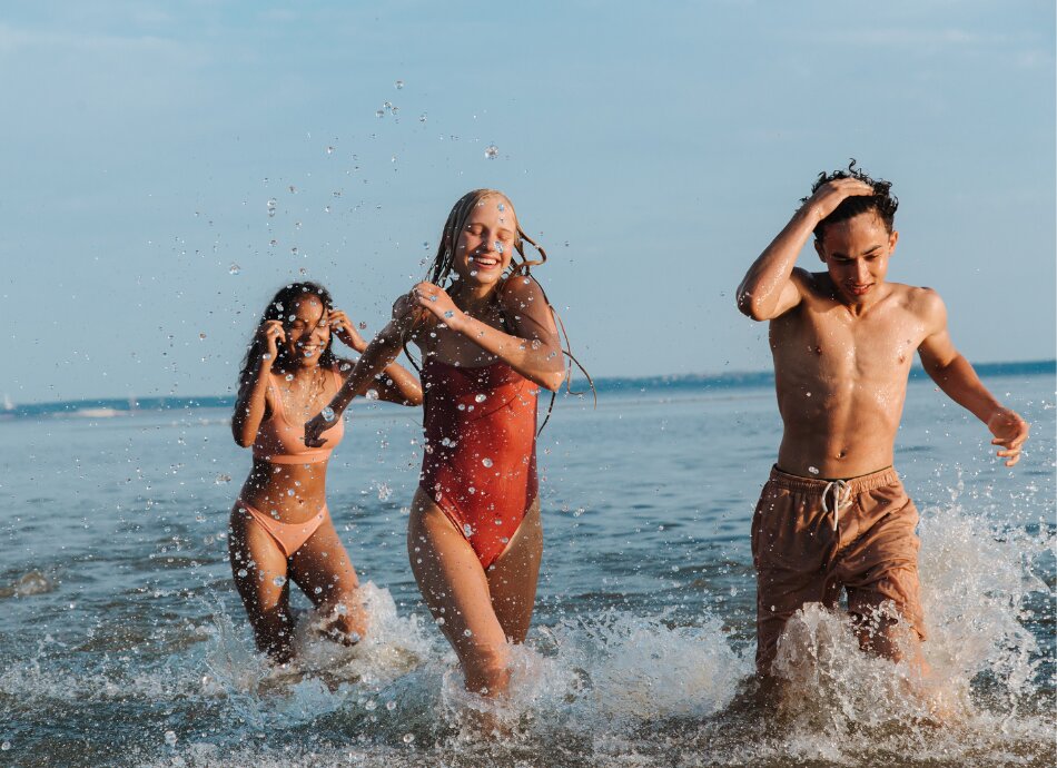 Teenagers running through surf at the beach