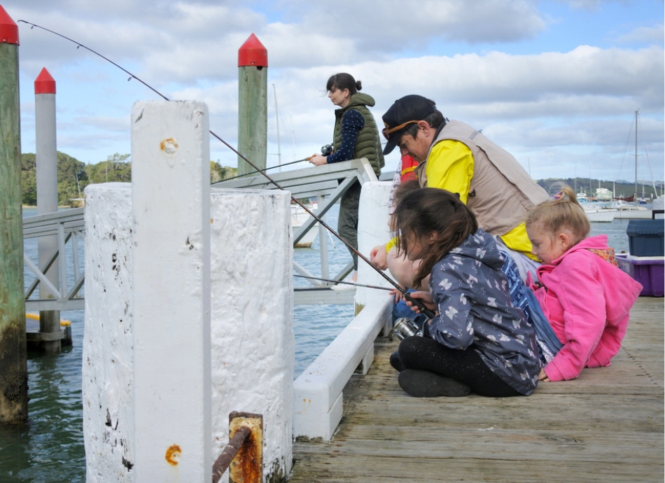 NZ family fishing from a jetty