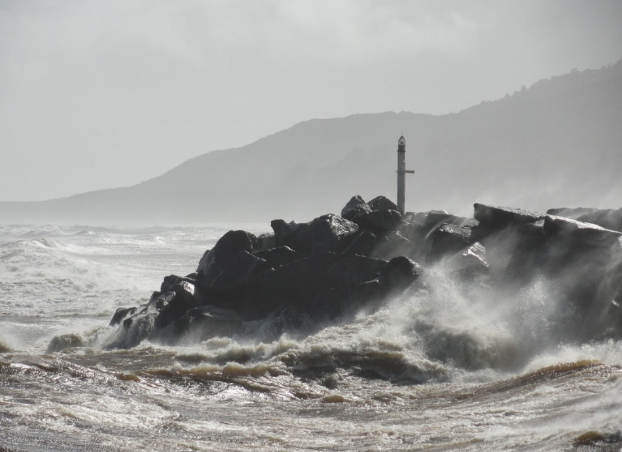 Rocky island in rough sea on West Coast of New Zealand